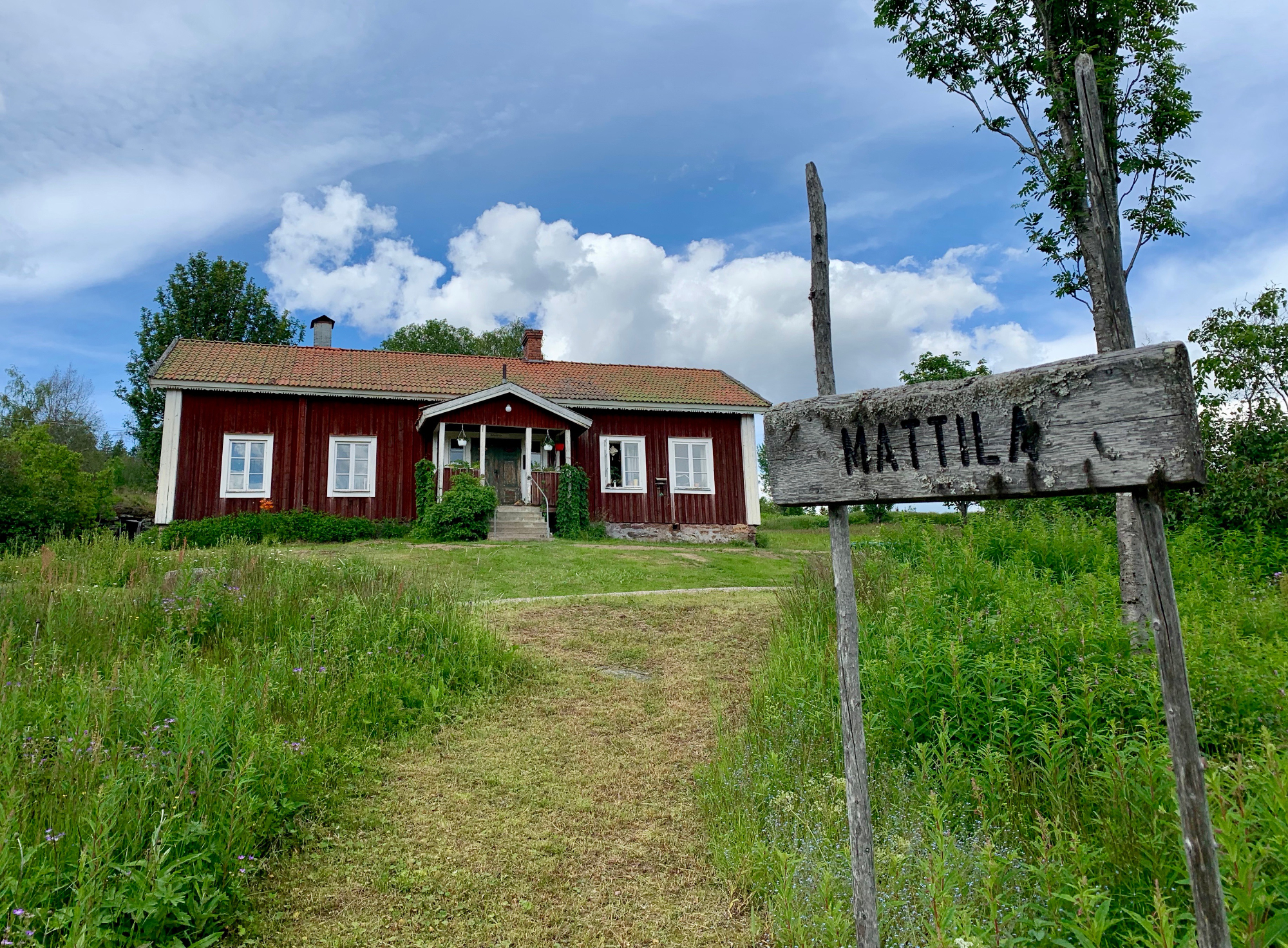 Ett rött hus med en gammal skylt "Mattila"